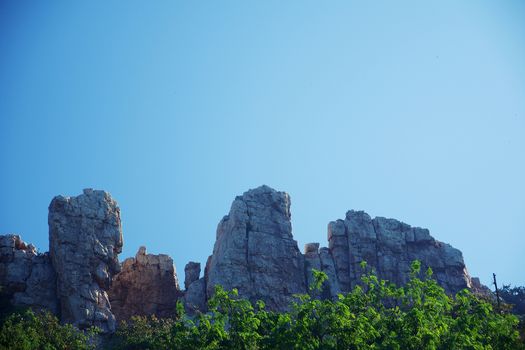 Rocky cliff and mountain against blue sky background for nature concept