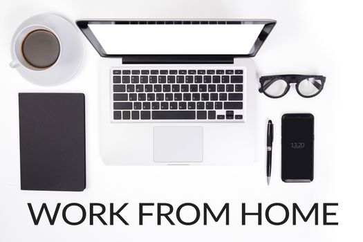 work from home concept. device accessories on office desk table such as notebook laptop computer , cup of coffee , glasses , pen , stationery, mobile smart phone and notebook with text work from home