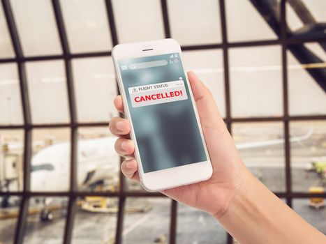 flight cancellation concept. announces message for flight schedule change information alert on smartphone application with airport terminal at background. 