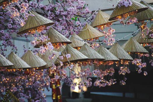 Beautiful Spring Festival decorations in Hanoi City made of pink cherry blossoms and Asian conical hat