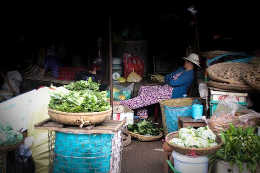 Editorial. A Khmer or Cambodian vegetable seller taking a nap in her market stall in the local market of Phnom Pehn, Cambodia