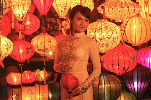 Editorial. A Female Vietnamese tourist posing for a photo among the famous Vietnamese lanterns in Hoi an, Vietnam