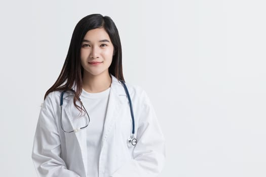 attractive Asian female doctor looking at camera with smiling face, isolated on white background with copy space. studio shot