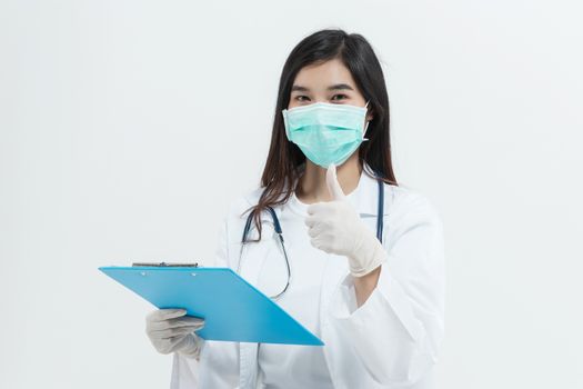 young Asian doctor woman wearing doctor gown uniform coat , medical mask and stethoscope holding a clipboard looking happy and showing positive with thumb up gesture.