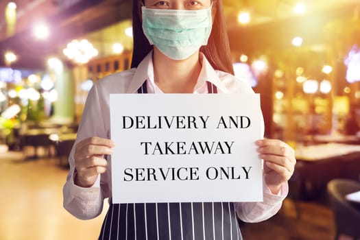 restaurant business operators affected by Coronavirus Covid-19 pandemic transmission must close shop for social distancing, showing customer announcement sign for delivery and takeaway service only