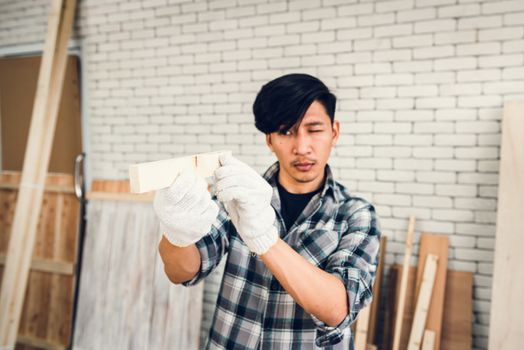 Carpenter Man is Working Timber Woodworking in Carpentry Shop, Craftsman is Aiming Alignment Timber Plank for Wooden Furniture in Workshop. Workmanship and Job Occupation Concept