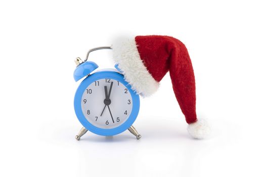 Blue alarm clock with red santa hat isolated on white background