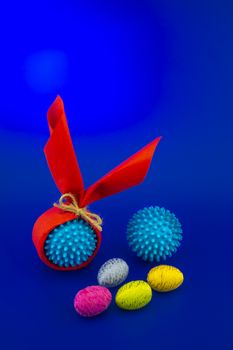 Corona virus models wrapped as gifts and Easter eggs on a blue background with copy space