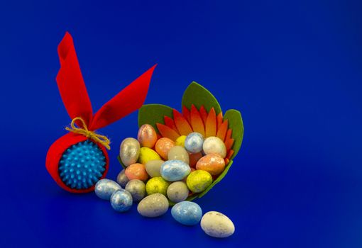 Corona virus models wrapped as gifts and Easter eggs on a blue background with copy space