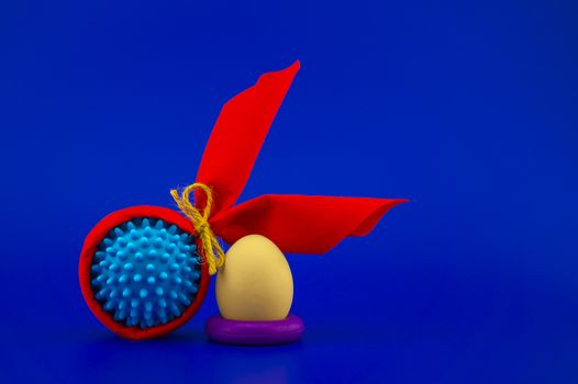 Corona virus models wrapped as gifts and Easter eggs on a blue background with copy space