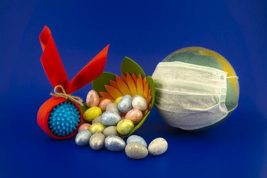 Easter eggs and corona virus models wrapped as gifts on a blue background with copy space.