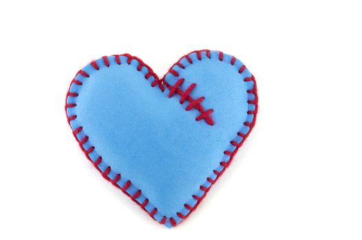 One handmade blue felt stitched toy heart on white background. Love, relationship, Valentines Day, broken heart concept