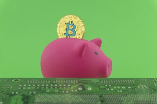 Saving using Bitcoin concept with a virtual gold coin being inserted into a pink piggy bank over a green background