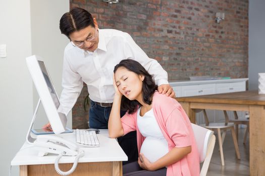 Husband comforting his suffering pregnant wife at home