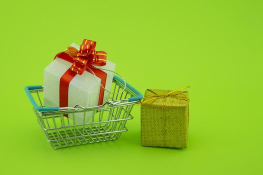 Shopping for gifts concept with shopping basket and gifts with decorative red ribbons