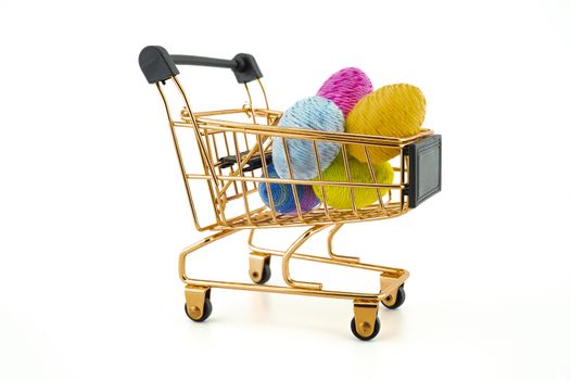 Shopping cart with Easter eggs isolated on white background