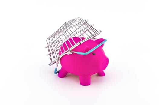 Cost of shopping or spending savings concept with a piggy bank and small wire shopping basket and cart isolated on white background