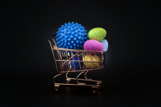 Virus molecule on a shopping cart and creative colorful eggs made from yarn conceptual of the possibility of infection with corona virus or Covid-19 over a black background