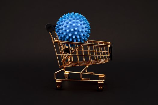 Blue virus molecule on a shopping cart conceptual of the possibility of infection with corona virus or Covid-19 over a black background