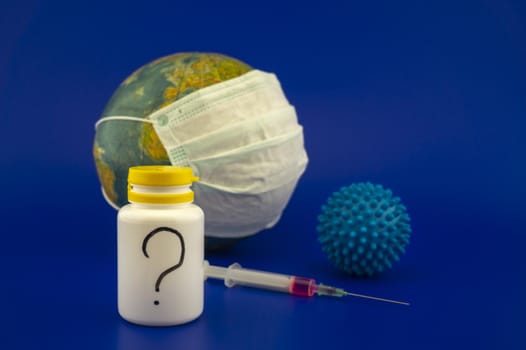 Concept of research for a Covid-19 vaccine with a hypodermic syringe, pharmaceutical bottle and blue virus molecule in front of a globe with protective face mask over a blue background with copy space