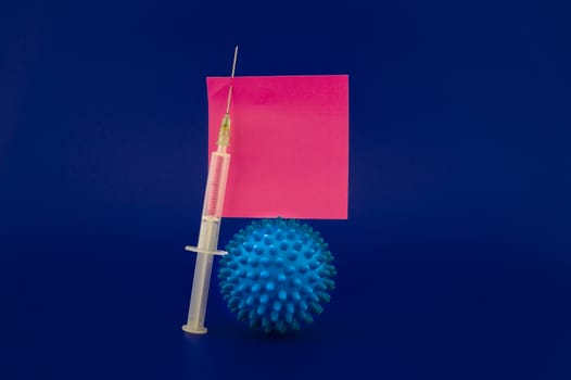 Virus pandemic and possible vaccine concept with hypodermic syringe and blue virus molecule in blue toned theme with blank square of paper note for text