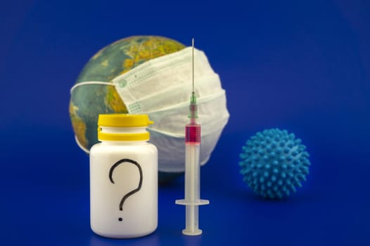 Concept of research for a Covid-19 vaccine with a hypodermic syringe, pharmaceutical bottle and blue virus molecule in front of a globe with protective face mask over a blue background with copy space