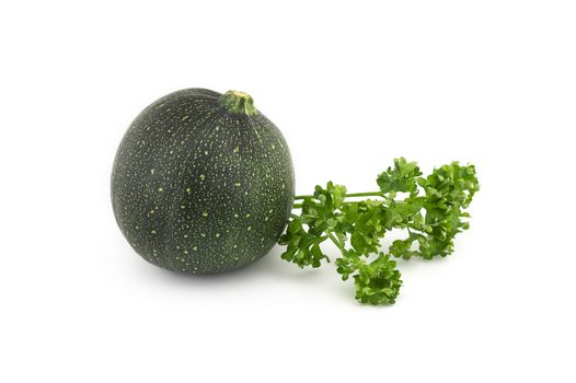 Green round courgette or zucchini and fresh parsley sprigs isolated on white background