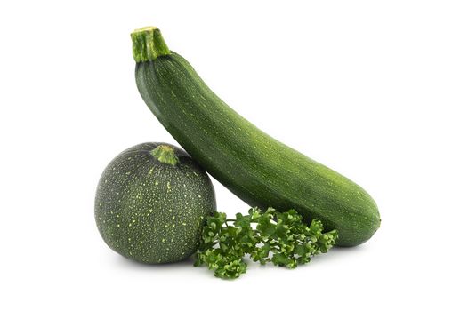 Green round and traditional courgette or zucchini, fresh parsley sprigs isolated on white background