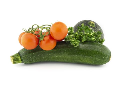 Green round and traditional courgette or zucchini, cherry tomato twig and fresh parsley sprigs isolated on white background