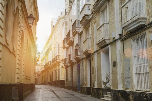 Sun Rays On A Narrow Street With Traditional Architecture In Cadiz, Andalusia, Southern Spain