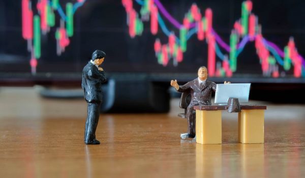 Miniature figure business people or Stock Trader meeting and consulting in front of Blur Price Stock graph board for Graph Analysis