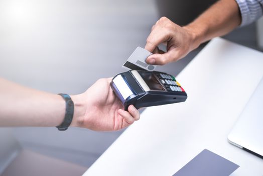 finance, payment, cash free and people concept - young man with credit card paying for coffee at city street cafe