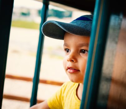 Little boy wearing blue cap portrait, outdoor setting