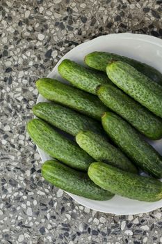 A stack of several fresh green cucumber gherkins in a plate, Sofia, Bulgaria