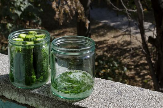 Two glass jars with the necessary preparation for  traditional home-made canning cucumbers, Sofia, Bulgaria