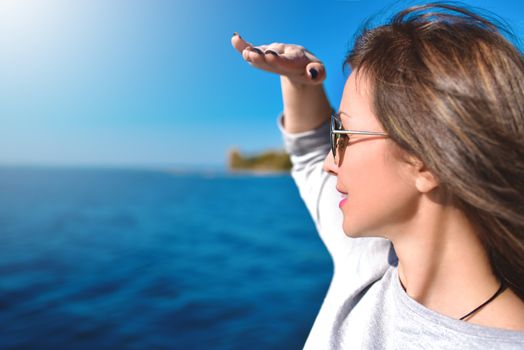 Beautiful woman looking ahead with the hand in forehead and the sea in the background