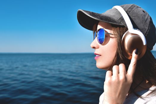 Happy joyful woman listening to music while being outdoor. Music concept.