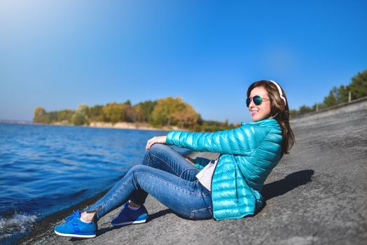 Happy joyful woman listening to music while being outdoor. Music concept.