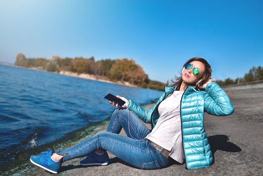 Happy joyful woman listening to music while being outdoor. Music concept.