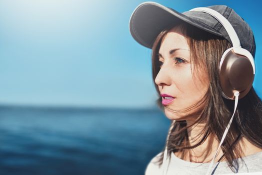 Happy joyful woman listening to music while being outdoor. Music concept.