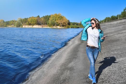 Happy joyful woman listening to music while being outdoor. Music concept.