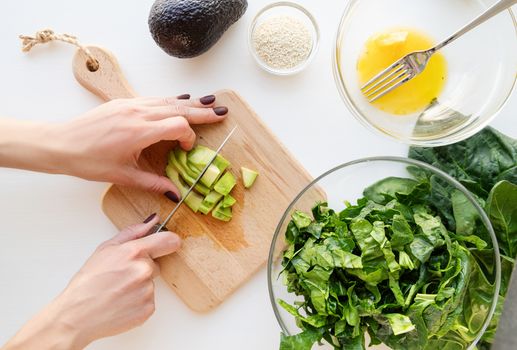 Step by step preparation of spinach, avocado and orange salad. Step 5 - cutting the avocado, top view, selective focus