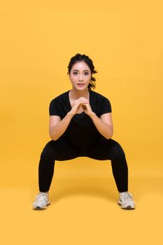 Smile happy Beautiful portrait young Asian woman stretching exercise workout on yellow background, fitness sport girl aerobic and healthy concept.