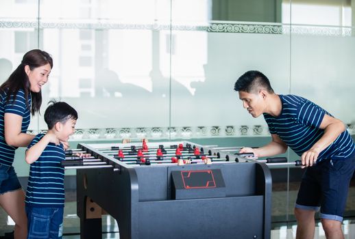 Happy Family playing table football for relax on holiday in home.Family activity on holiday concept