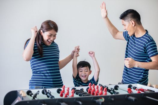 Happy Family playing table football for relax on holiday in home.Family activity on holiday concept