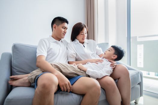 Happy Asian family with son at home on the sofa playing and laughing,Happy together for a holiday.