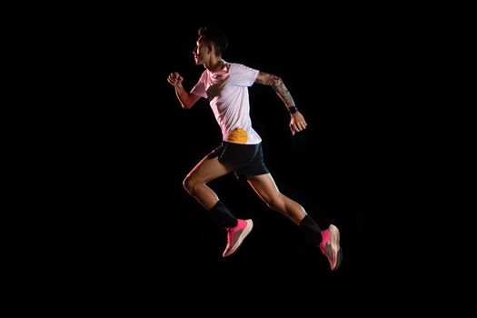 Asian man young sprinter runner running in studio on black background