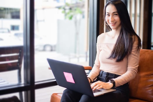 Asian businesswomen are using notebook computers for working from home.She is smile happy and enjoys working.