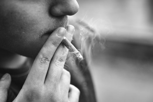 Guy smokes a cigarette outside,portrait,close-up, smoking man