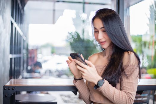 Smiling and happy Asian Business women are using mobile and touch smart phone for Communication and search for information .Technology communication lifestyles concept.